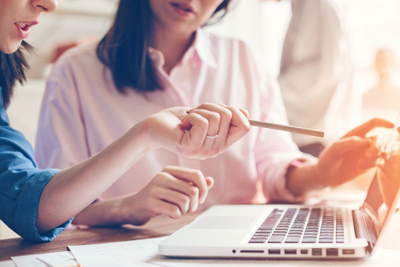 Two women looking at a laptop screen