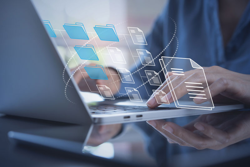 Stock photo of man at laptop with overlaid graphics hovering above screen