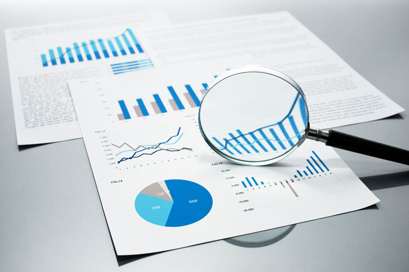 magnifying glass and graphs on paper