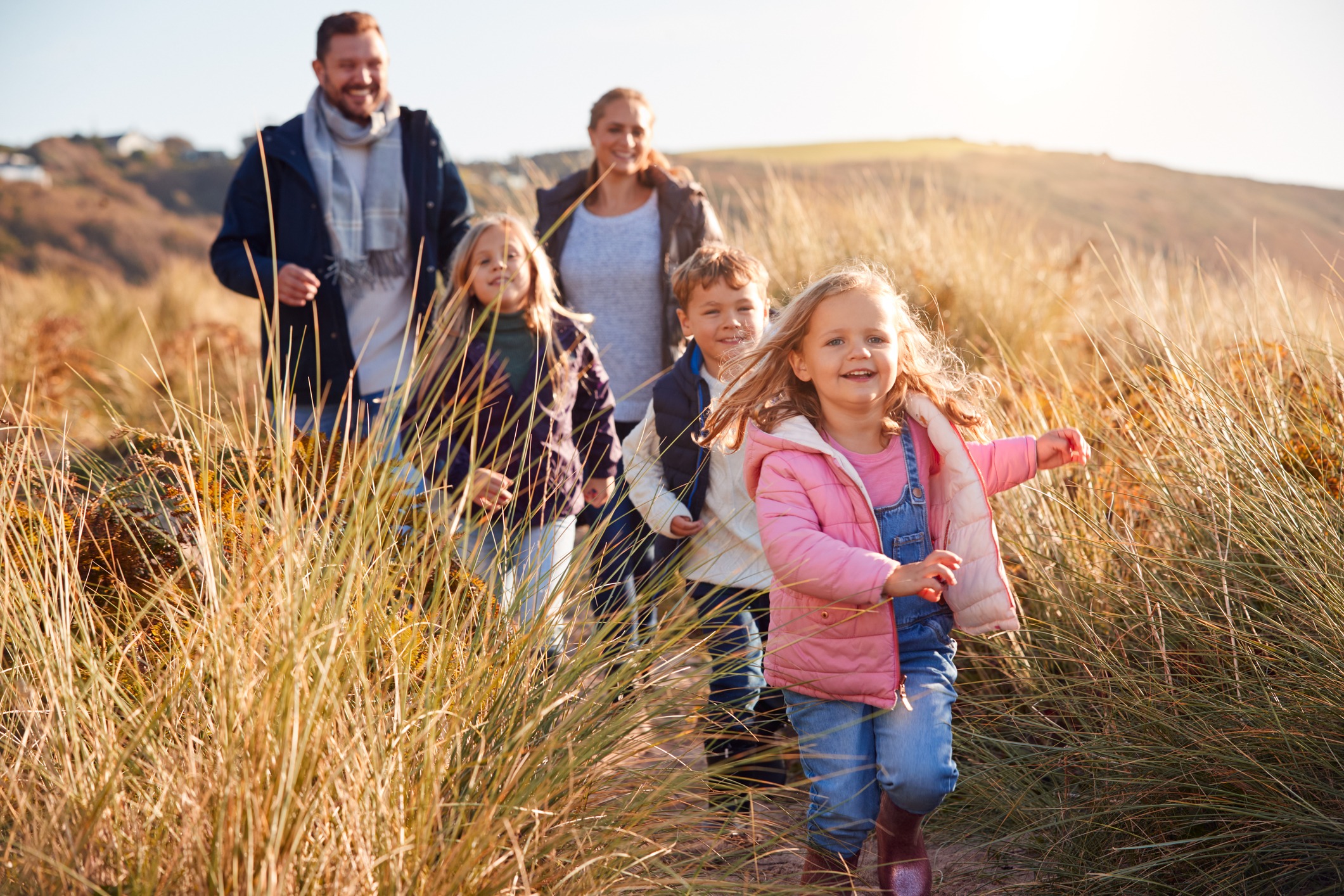 Family running over sand dunes