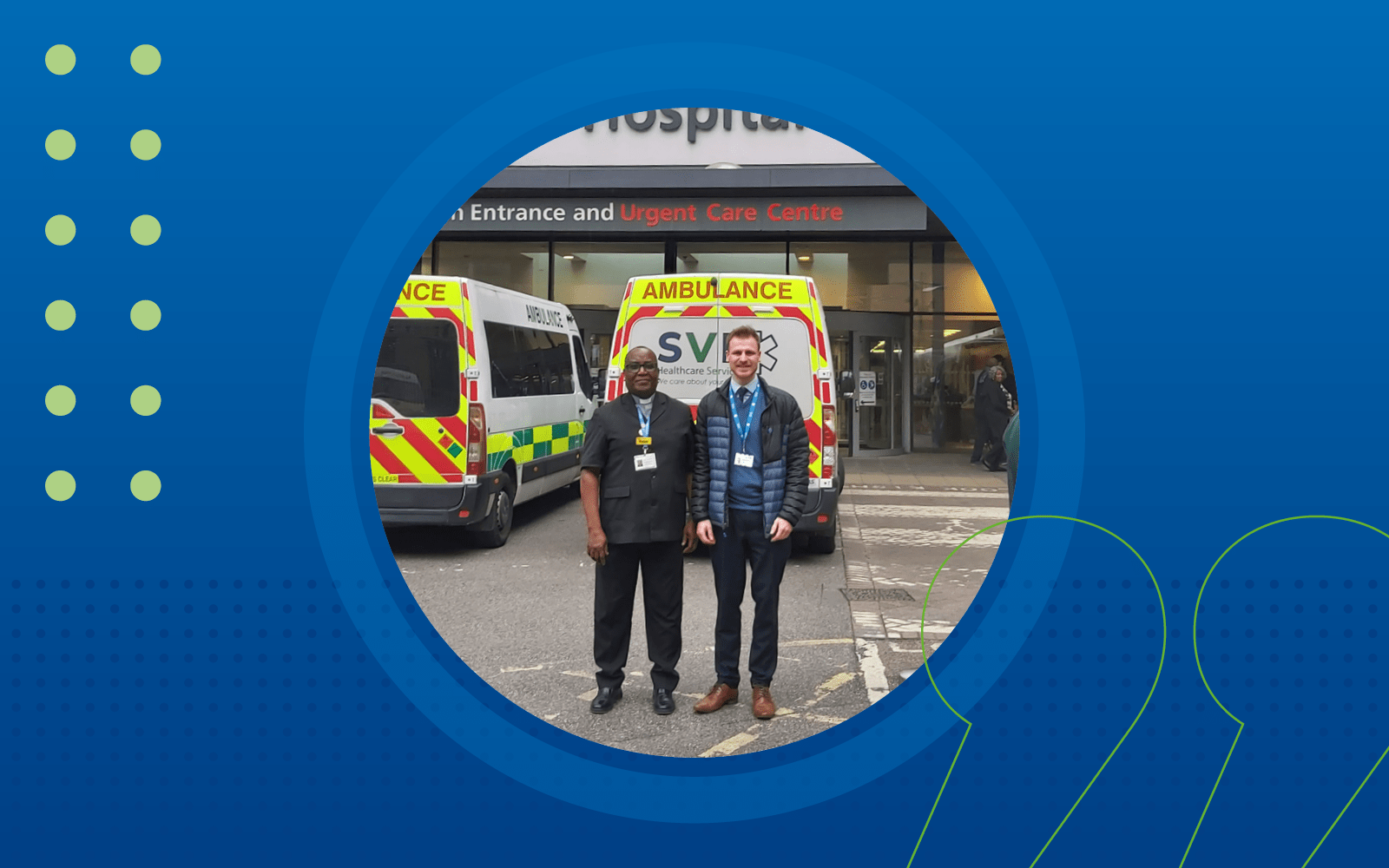 Simeon and male colleague standing in front of ambulances and hospital entrance