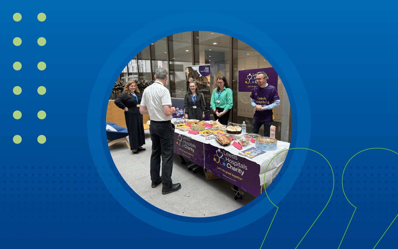 Caitlyn and members of the team stood behind a table full of cakes, and one person stood buying cakes