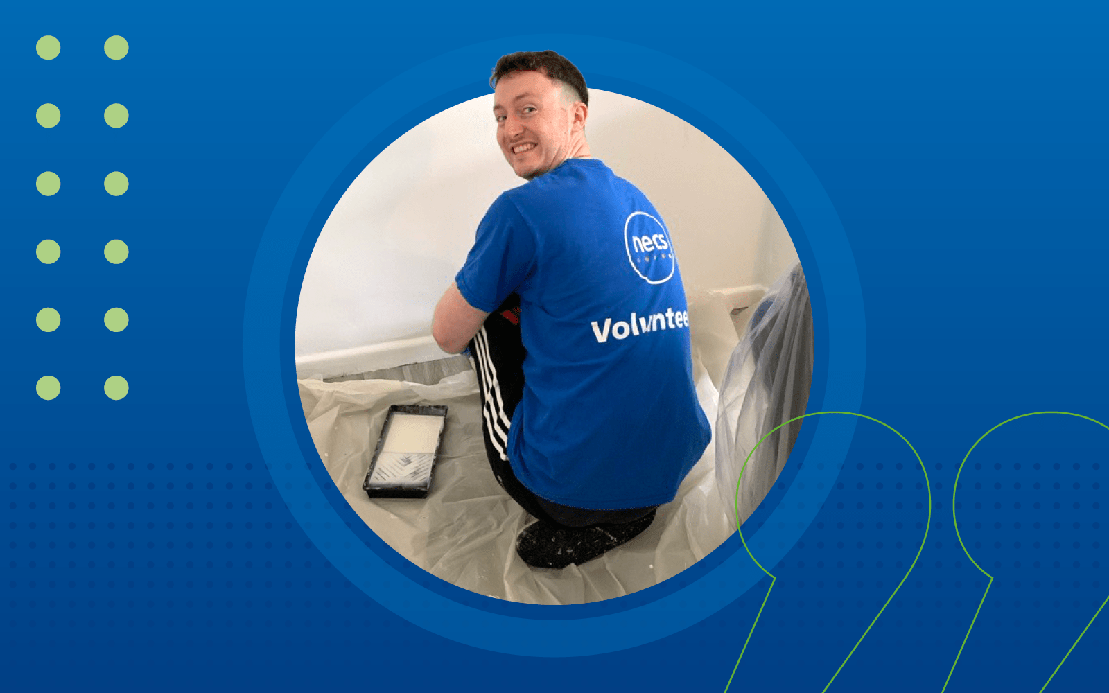 Will Bloor, a Graduate Consultant crouching down with a paint roller in hand decorating