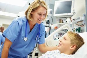 Female nurse caring for child in hospital